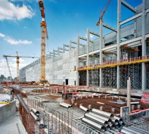 Navigating the Heat: Strategies for Construction - Commercial construction site with cranes and structural framework showing Iron Mechanical’s approach to heat management and safety strategies.