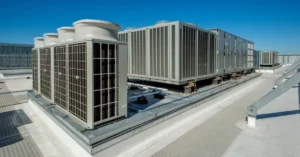 Large rooftop commercial HVAC units installed on a flat industrial building, showcasing energy-efficient climate control systems essential for maintaining indoor comfort and regulatory compliance.