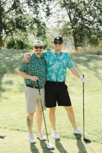 Two golfers smiling on the course during Iron Mechanical’s Copper for Kids Annual Golf Tournament charity event.