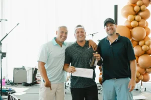 Three men celebrating together at Iron Mechanical’s Annual Golf Tournament award ceremony.