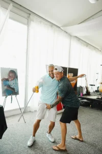 Two men sharing a lighthearted moment at Iron Mechanical’s Annual Golf Tournament fundraiser event.