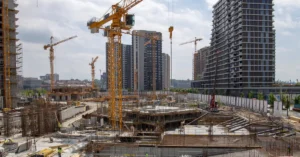 Large urban construction site with multiple cranes and high-rise buildings under development, illustrating the scale and complexity of modern commercial construction projects.