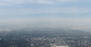 How to Improve Indoor Air Quality: 10 Tips for Northern California - City skyline covered in smog, illustrating the importance of indoor air quality solutions by Iron Mechanical.