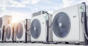 Row of commercial HVAC outdoor condenser units on a rooftop, designed for energy-efficient climate control in large-scale residential or commercial buildings.