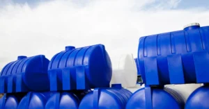 Stack of blue and white plastic water storage tanks designed for commercial use, commonly utilized in rainwater harvesting and water reservation systems.