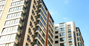 High-rise multifamily residential buildings with modern balconies and large glass windows, illustrating contemporary construction trends in urban housing development.