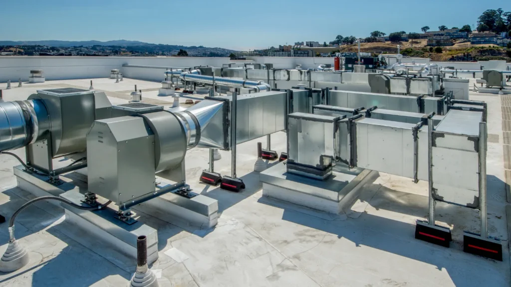 Commercial rooftop HVAC system with multiple ducts and ventilation units, illustrating large-scale air handling solutions for industrial or office buildings.